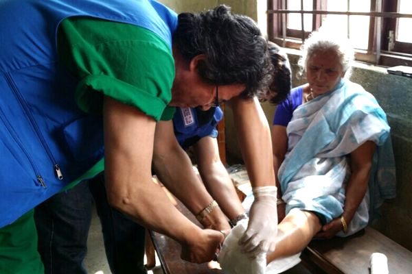 지진에 의해 부러진 환자의 발목을 고정시키는 장면. 구호대를 찾은 환자 상당수가 지진에 의한 직접 피해자였다는 게 강원봉 원장의 설명이다.